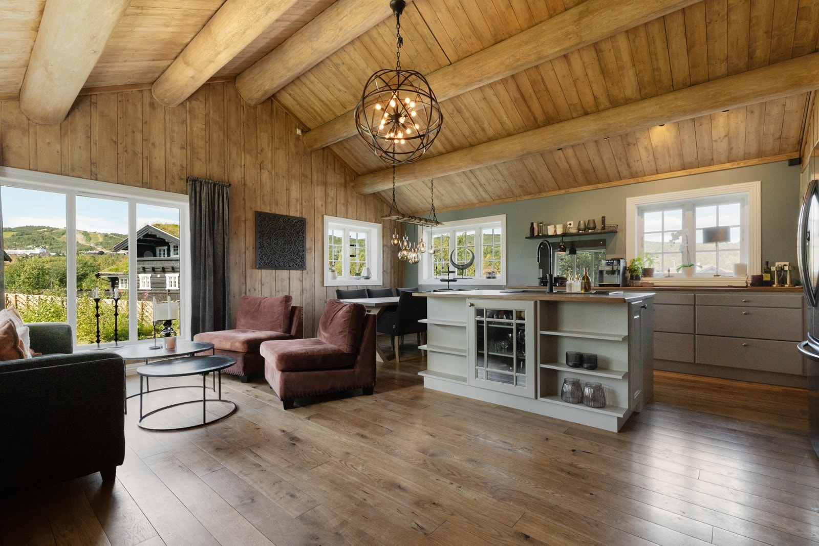 Det sosiale rommet har åpen kjøkkenløsning mot sofa- og spiseplass Galleribilde