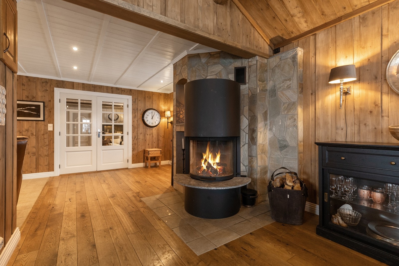 Flott peis med panoramaglass. Muren er forblendet med skifer og har nisjer for ved og interiør Galleribilde