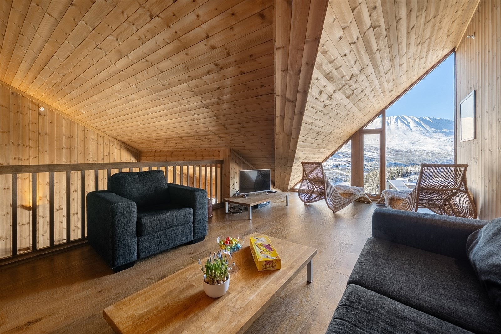 Stuen er delt inn i to soner. Den ene sonen ligger ved de store vinduene som strekker seg fra gulv til tak, hvor du kan sitte og nyte den spektakulære utsikten og virkelig føle deg som en del av naturen. Galleribilde