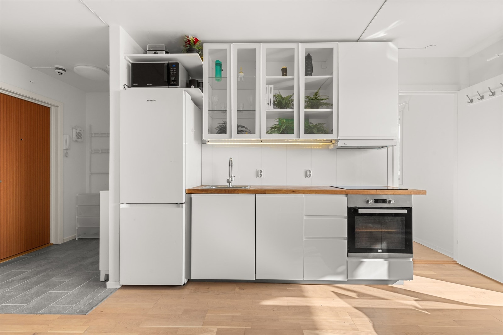 Kjøkkeninnredningen er med glatte fronter og heltre benkeplate med nedfelt vaskekum. Det er rikelig med oppbevaring i skuffer og skap, og den store benkeplaten gjør det enkelt å diske opp lekre retter til familie og venner. Galleribilde