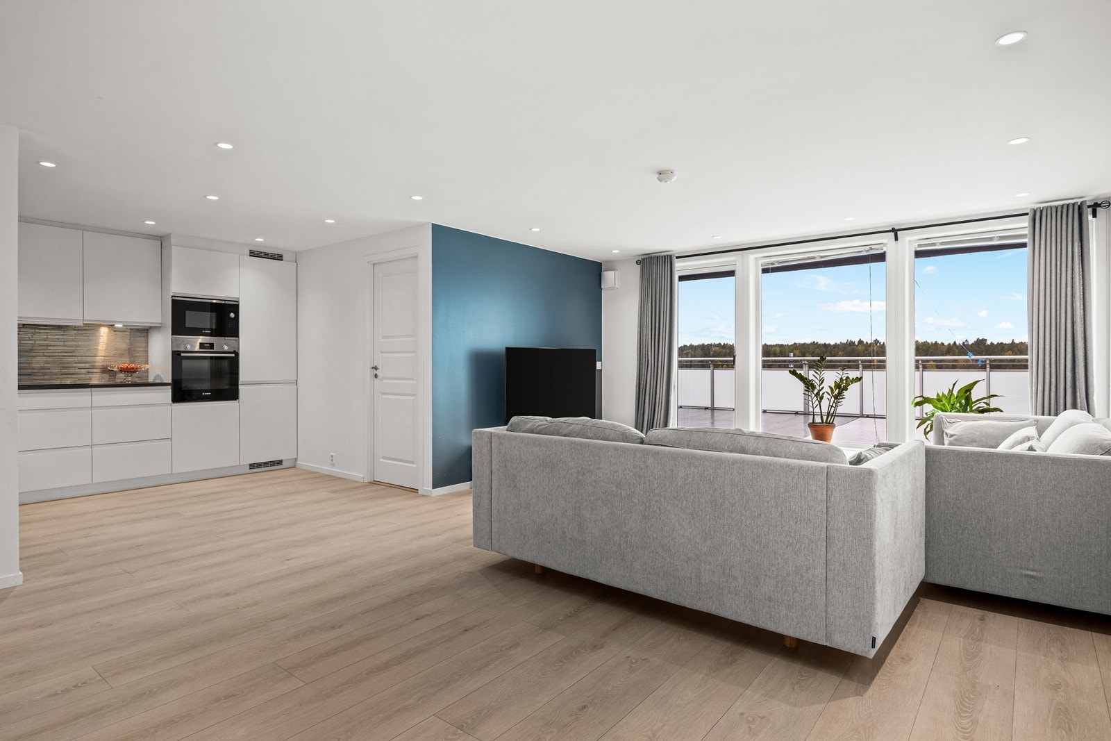 Stue og kjøkken i åpen løsning som skaper god kontakt mellom rommene Galleribilde