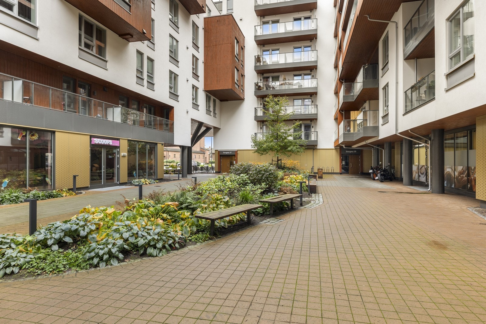 Sameiet har et pent opparbeidet og skjermet gårdsrom med beplantning og sitteplasser. Galleribilde