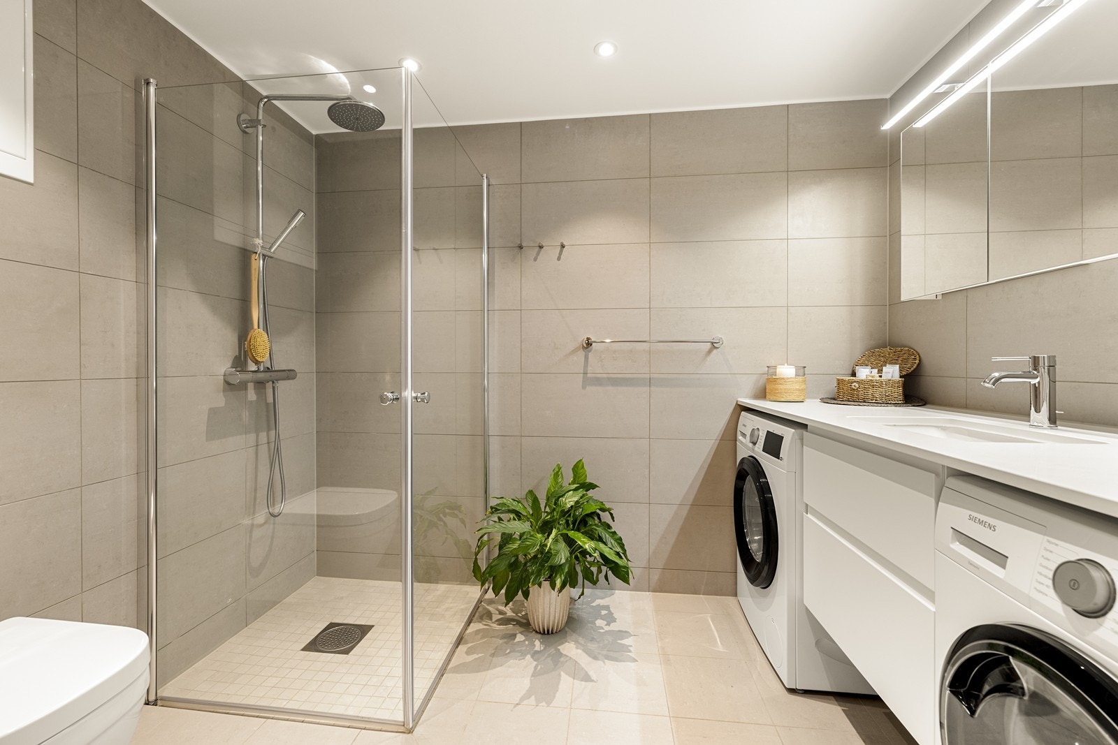 Boligen har to delikate bad. Dette er det største, med romslig dusj og opplegg for vaskesøyle. Galleribilde