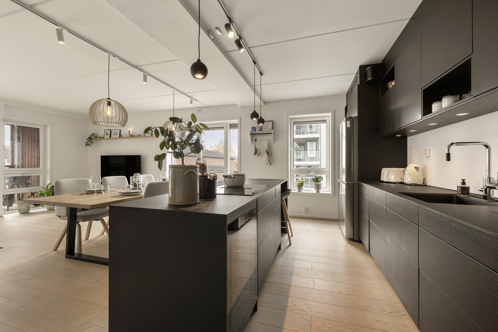 Fra kjøkkenet har man god oversikt over hele oppholdsrommet, og man kan lage mat uten å måtte snu ryggen til gjestene. Galleribilde