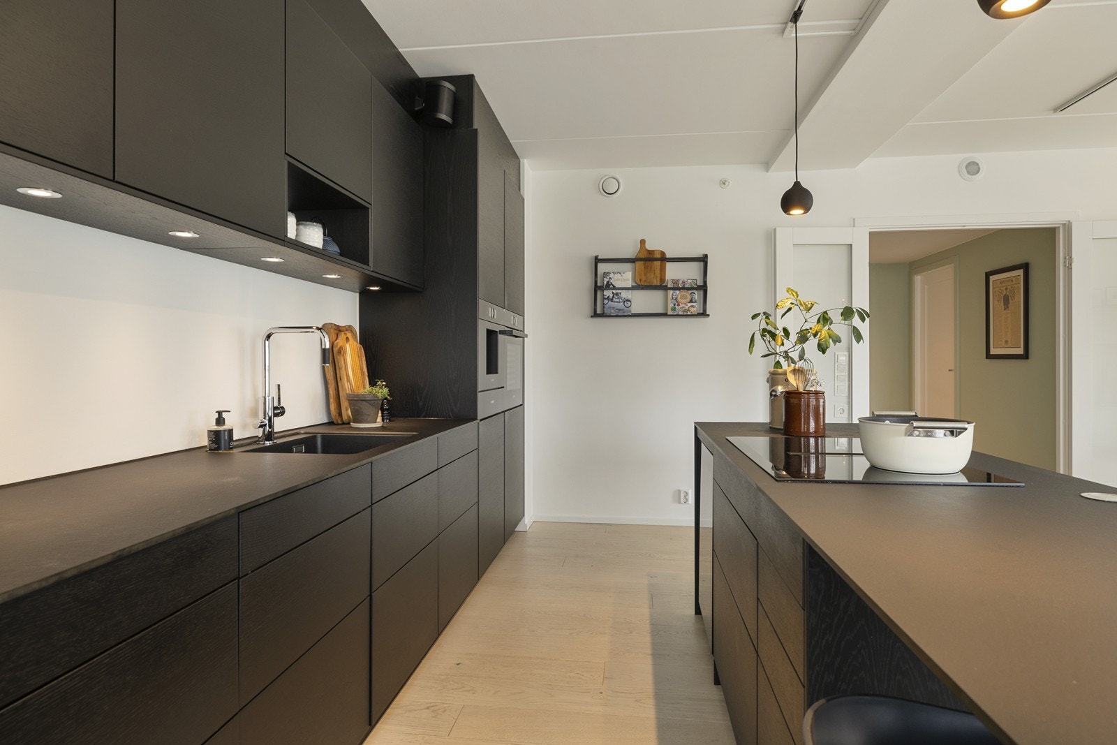 Innredningen har stilrene, glatte fronter og en robust benkeplate i komposittmateriale, samt integrerte høyttalere som kan gi musikk til arbeidet. Galleribilde