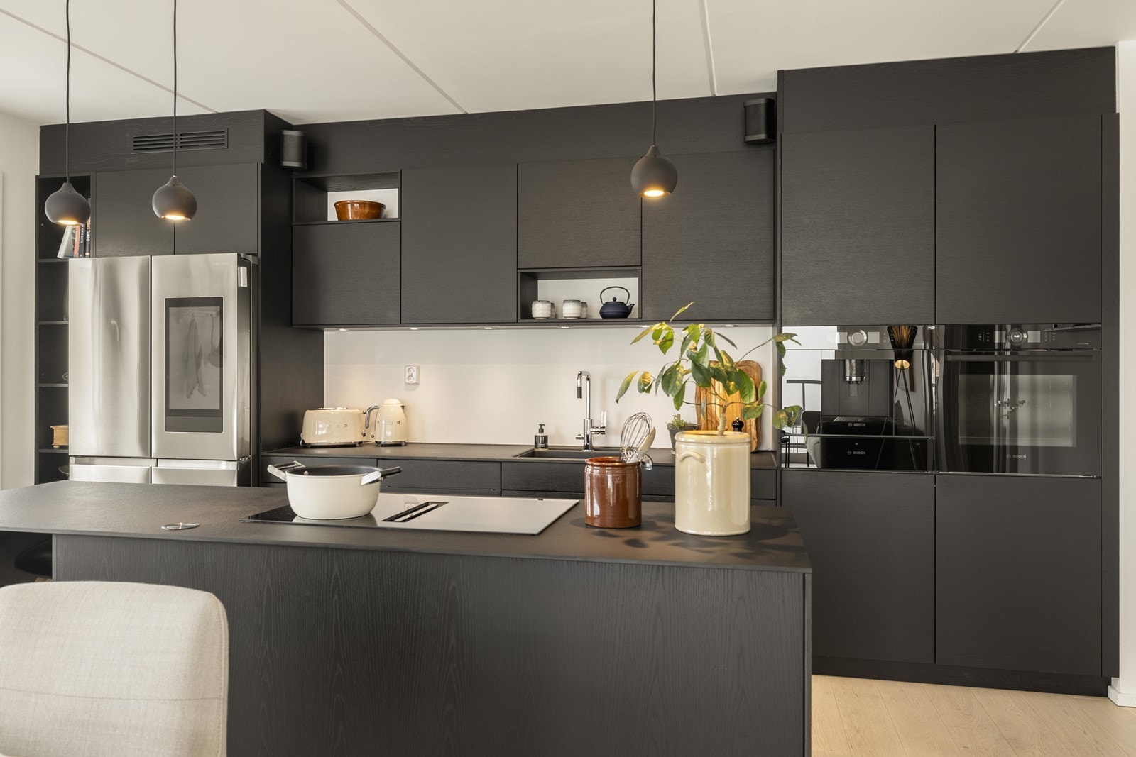 Her er det et komplett sett med integrerte hvitevarer, inkludert et romslig amerikansk kjøleskap, kaffemaskin, tallerkenvarmer og komfyr. Galleribilde