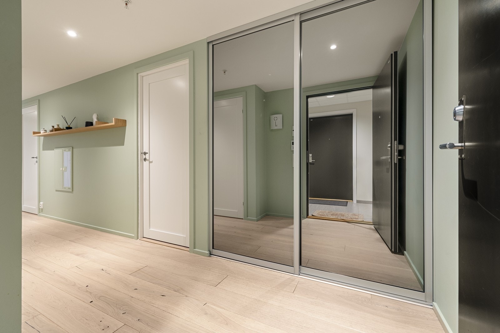 Leiligheten har en romslig og innbydende entré med god plass til oppbevaring av yttertøy og sko i en praktisk skyvedørsgarderobe. Gangen har, som resten av oppholdsrommene, behagelig vannbåren gulvvarme. Galleribilde