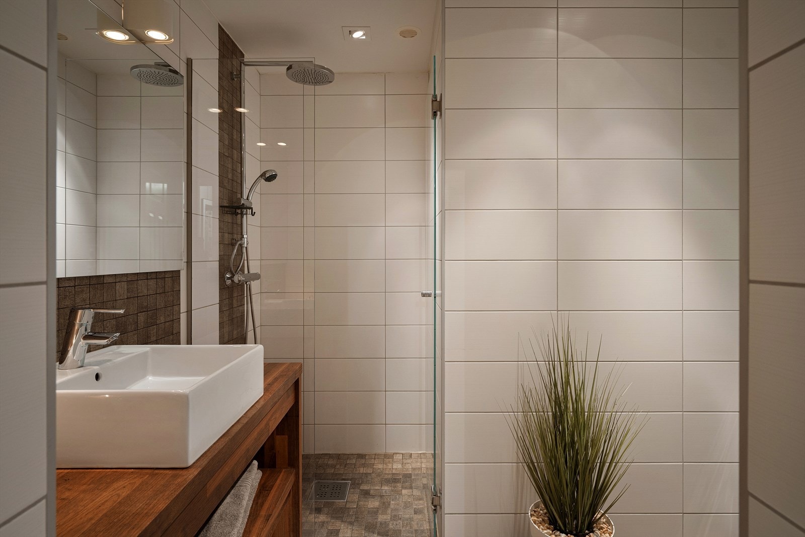 Tidløst bad med fliser på både gulv og vegger. Downlights i himlingen og malte overflater moderne uttrykk. Galleribilde