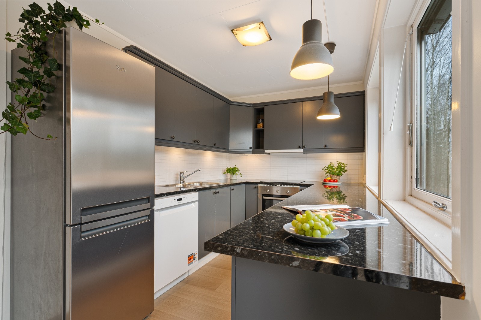 Kjøkken bestående av rikelig med skap- og benkeplass med vindu ut mot rolige grøntområder. Galleribilde