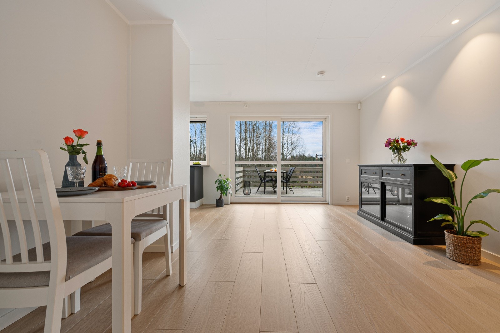 Stor stue bestående av moderne overflater, pent gulv av laminat og malte overflater. Downlights i tak. Galleribilde