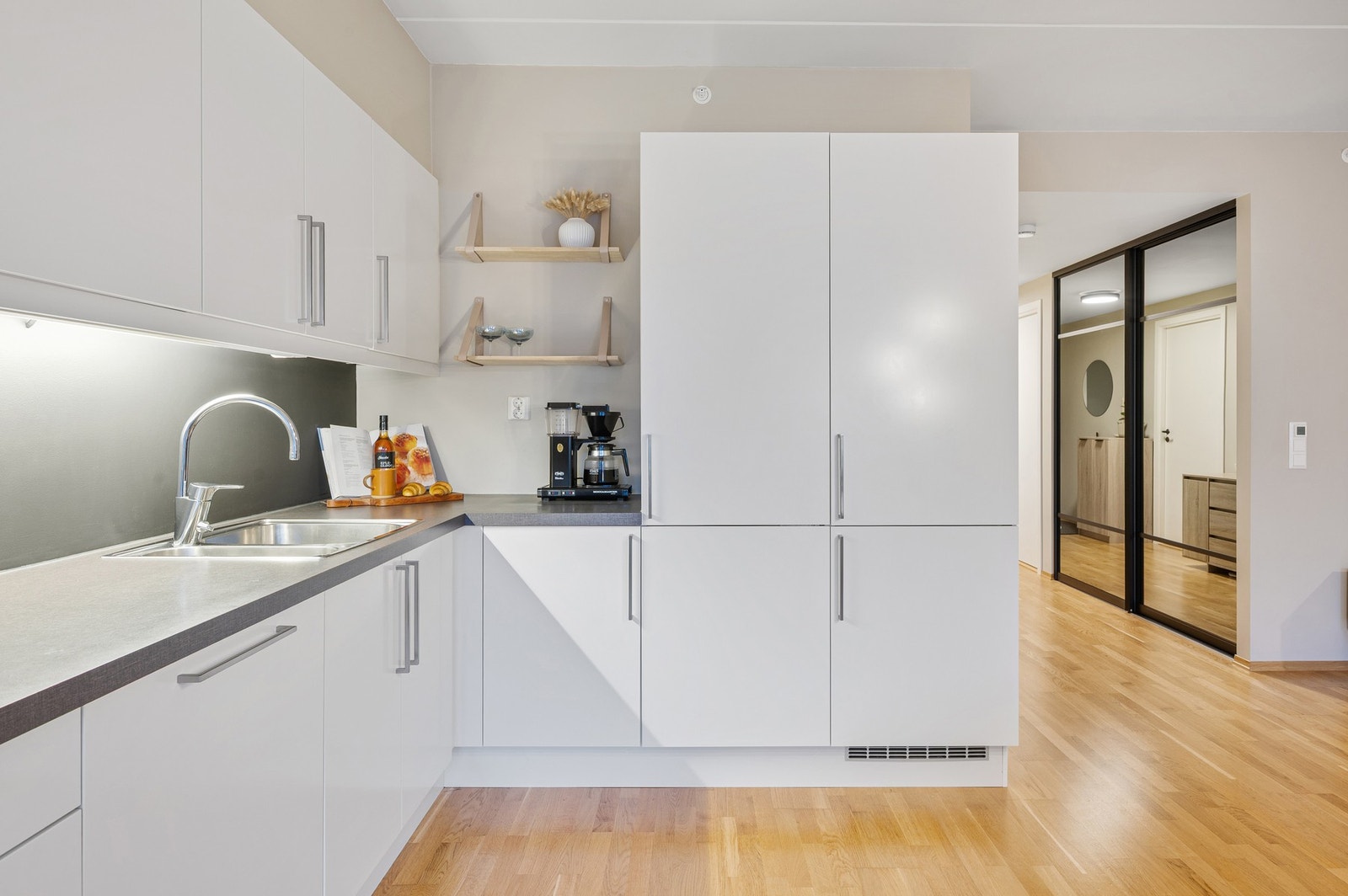 Kjøkkeninnredning med plane fronter og laminerte benkeplater. Galleribilde