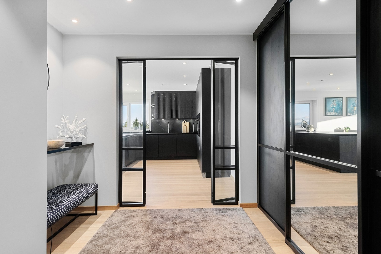 Entre har god oppbevaringsmulighet med en stor skyvedørsgarderobe Galleribilde