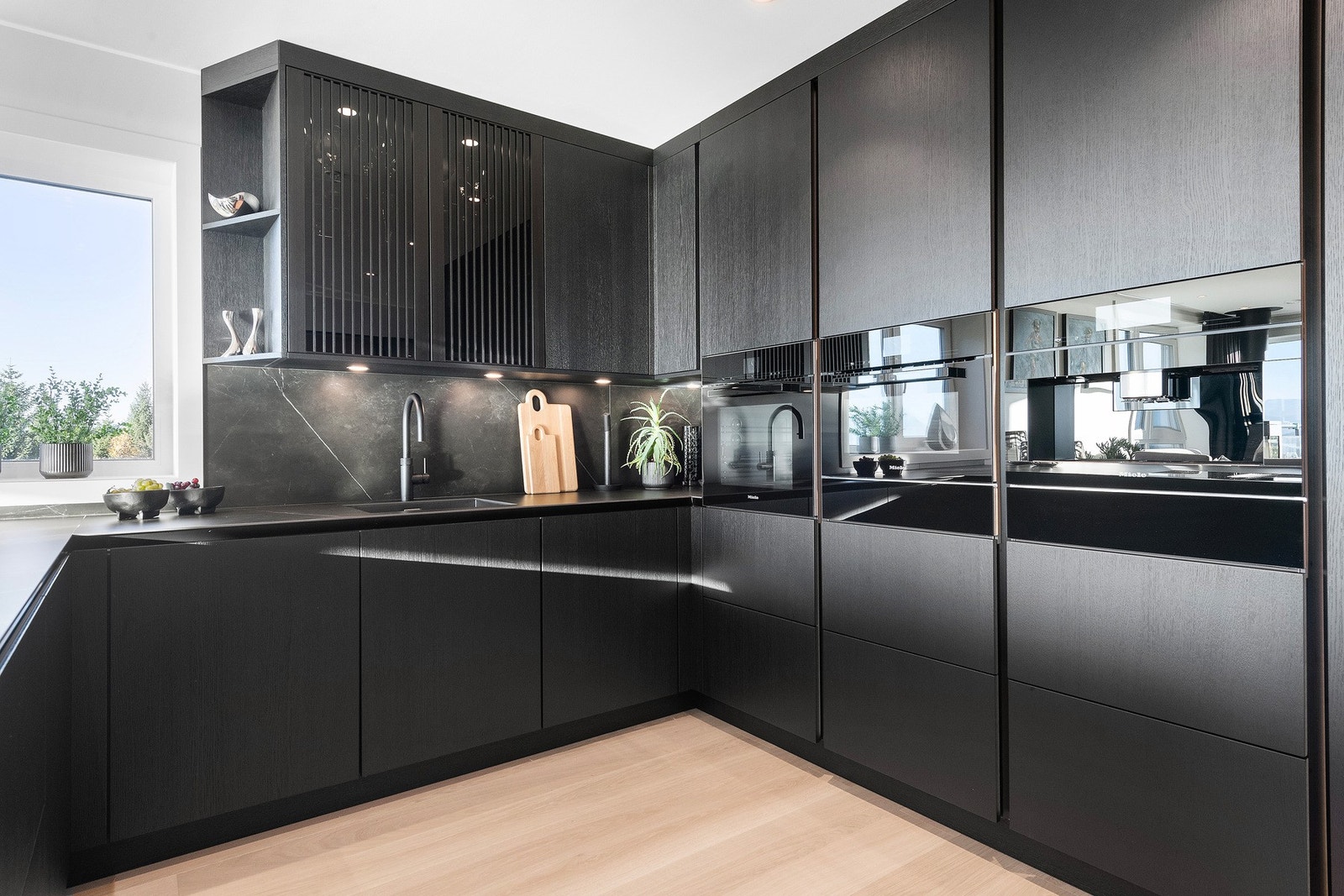 Innredningen har finerfronter, takhøye overskap for utnyttelse av plassen og keramisk benkeplate. Integrerte hvitevarer. Galleribilde