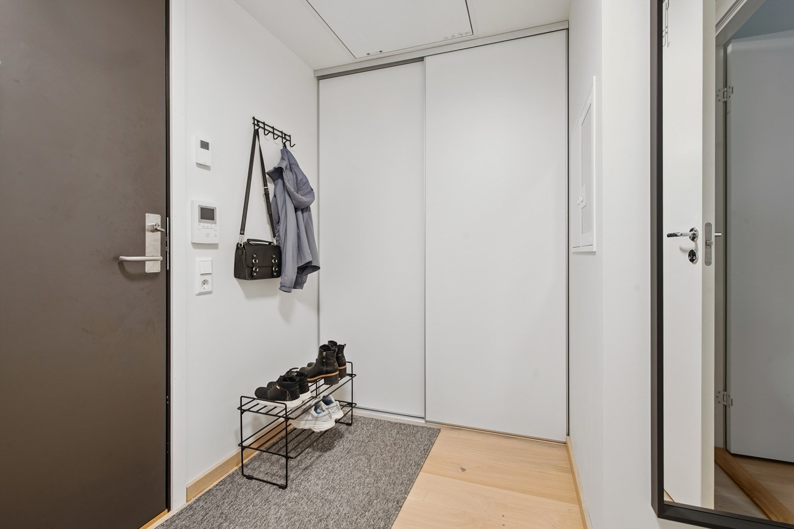 Romslig entré med skyvedørsgarderobe til klær og sko. Galleribilde