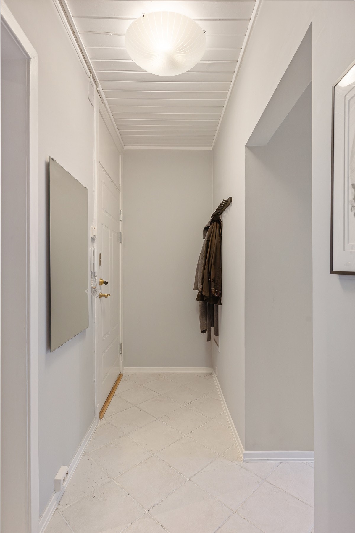 Innbydende entré med plass til ytterklær og sko. Dørcalling med åpner. Galleribilde