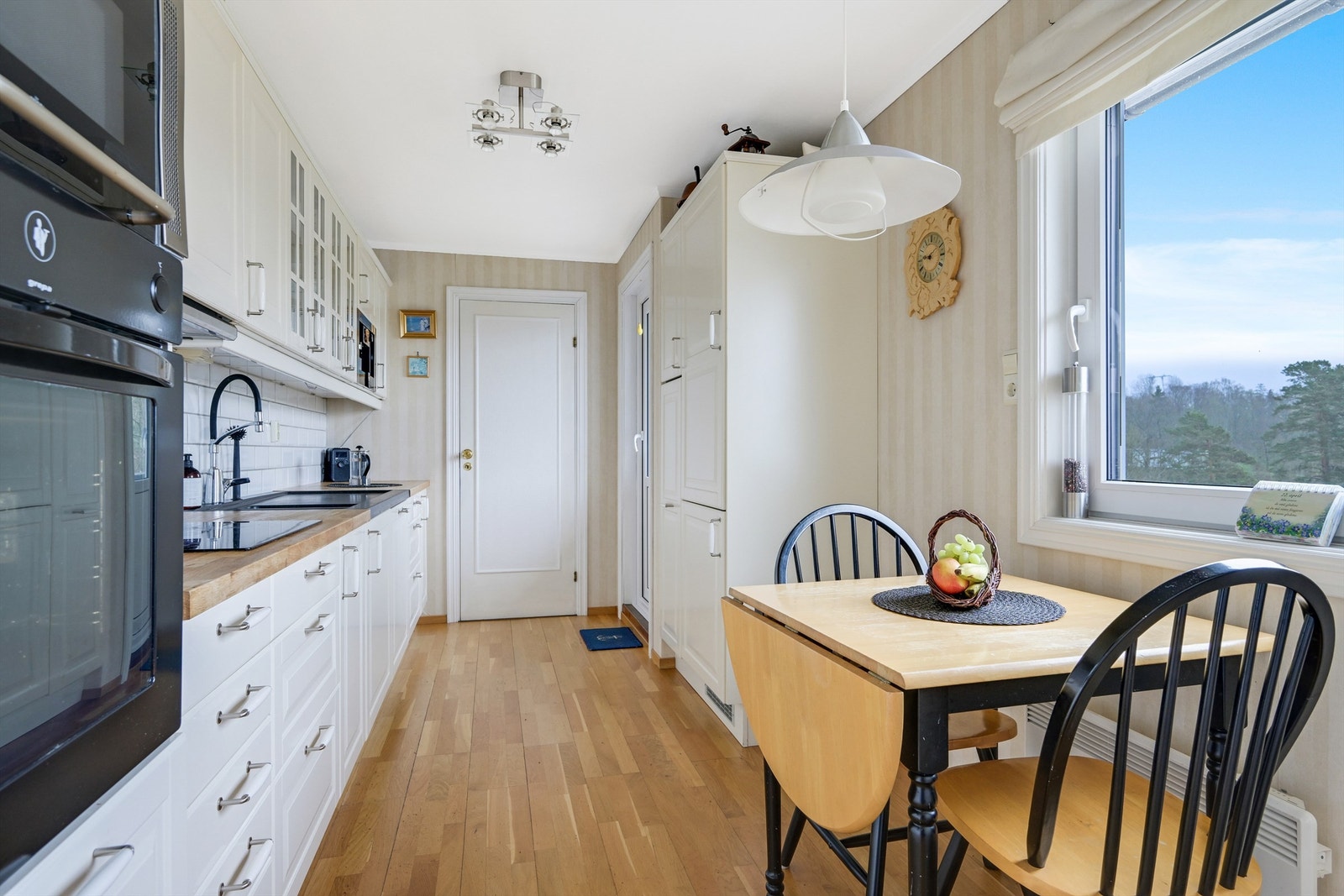 Lyst og hyggelig kjøkken med profilerte fronter og benkeplate av heltre. Galleribilde