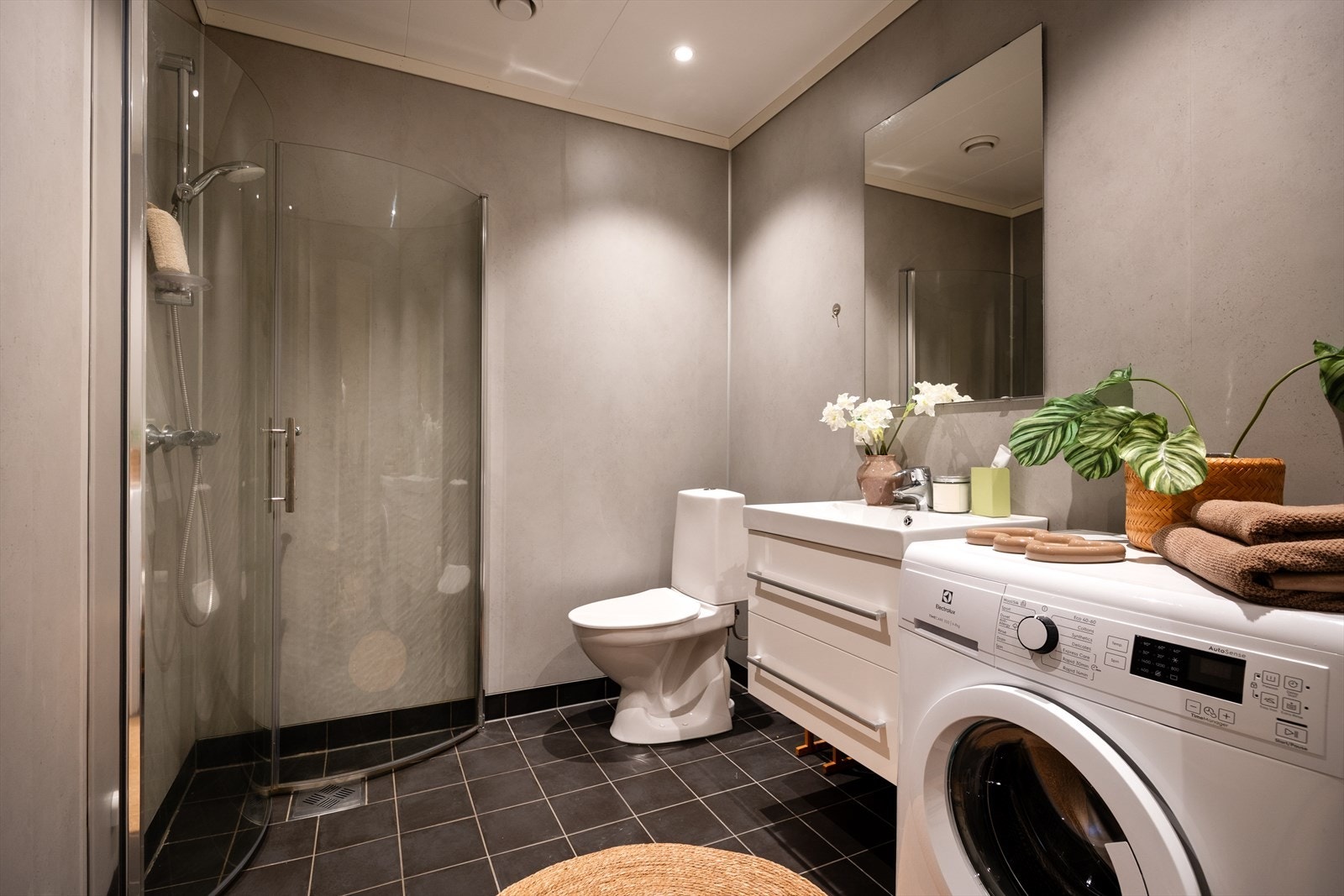 Bad med fliser og varmekabler i gulv, baderomsplater på vegg og opplegg for vaskemaskin. Galleribilde