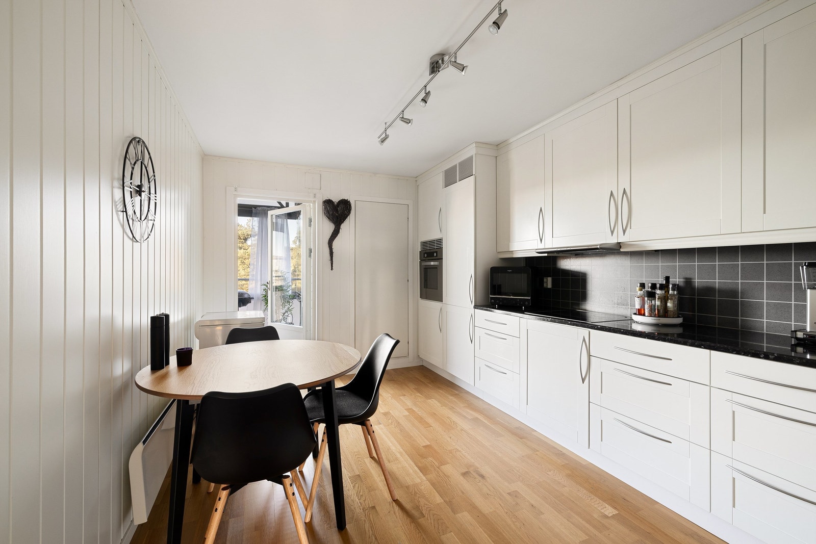 Fra kjøkkenet kan måltidene enkelt tas med rett ut i friluft på den innglassede verandaen. Kjøkkenet har også matbod. Galleribilde