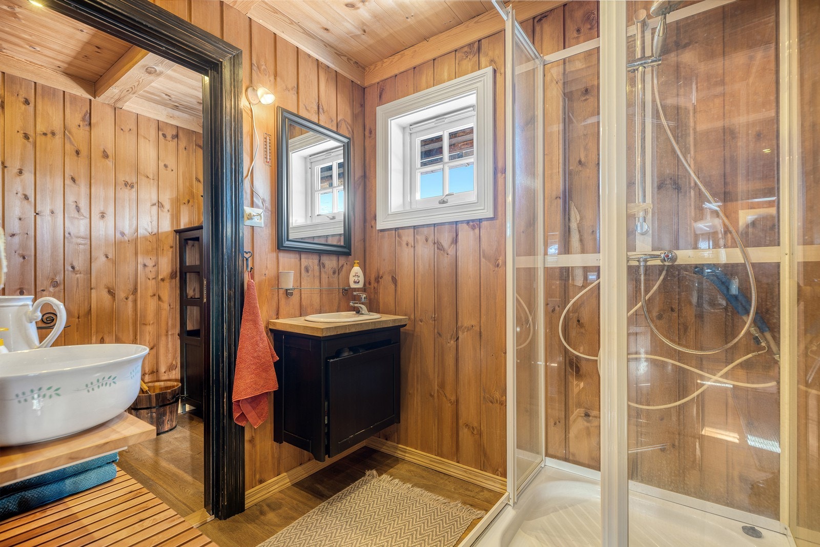 Baderom med dusjkabinett, baderomsinnredning og toalett. Galleribilde