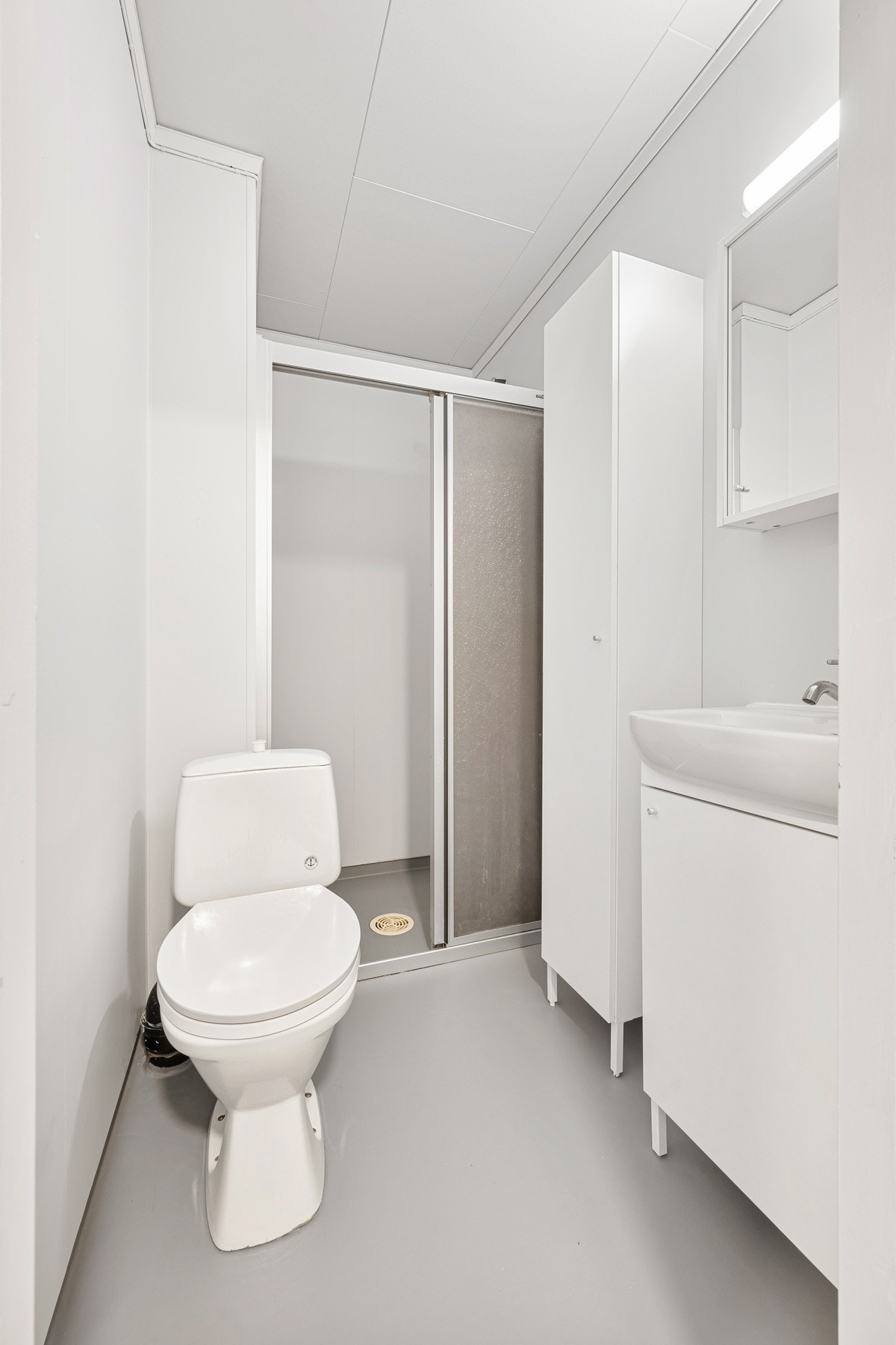 Badet ble overflateoppusset i 2024 og inneholder baderomsinnredning, høyskap, dusjhjørne og toalett Galleribilde