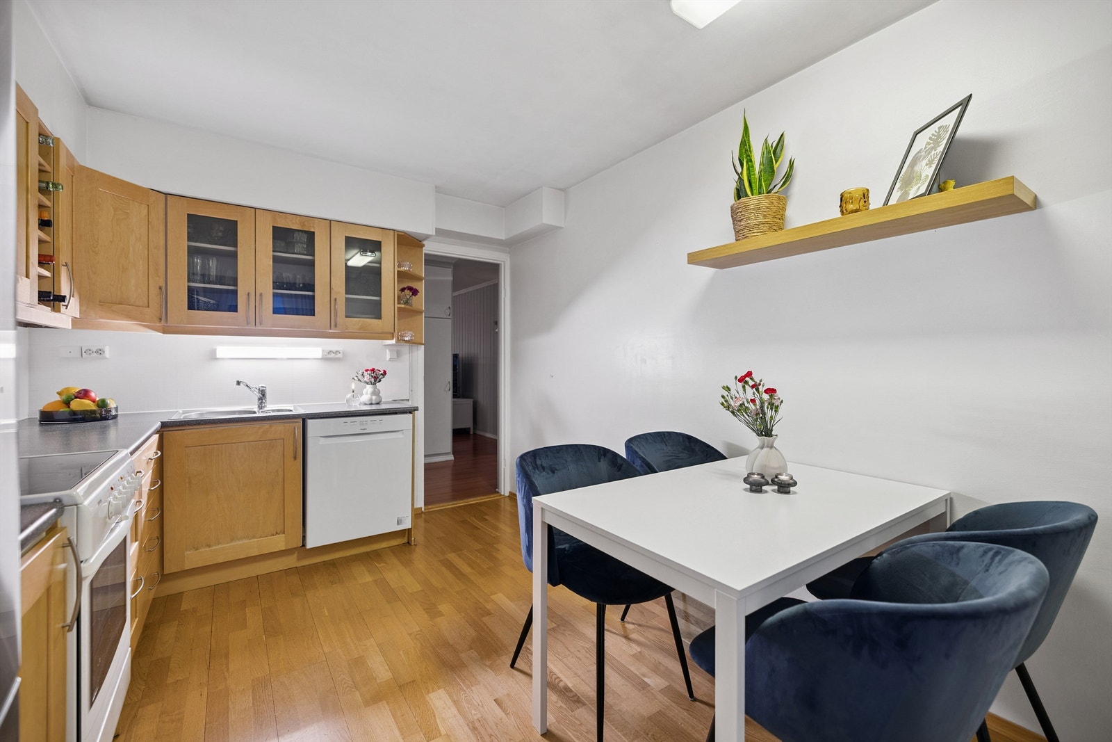 Kjøkkeninnredningen i tre har funksjonelle detaljer som vitrineskap og integrert vinstativ. Galleribilde