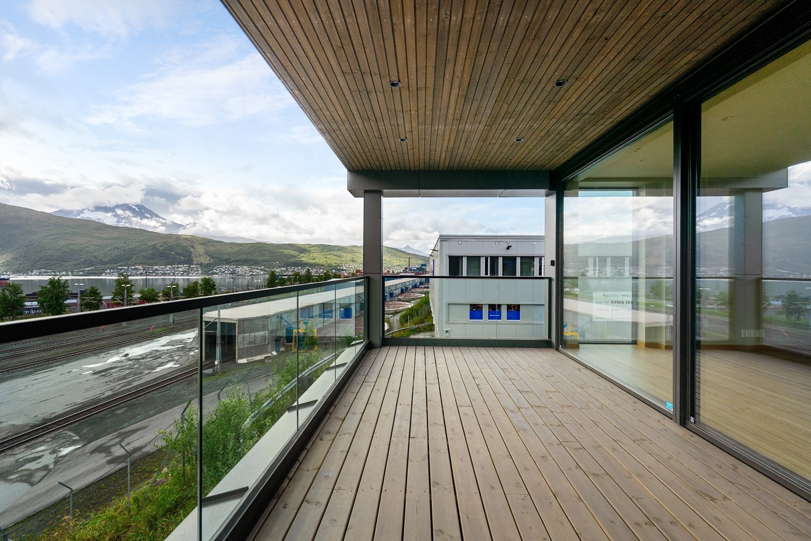 Stor, overbygd veranda med glassrekkverk og god plass til sittegruppe - perfekt for å nyte late sommerdager Galleribilde