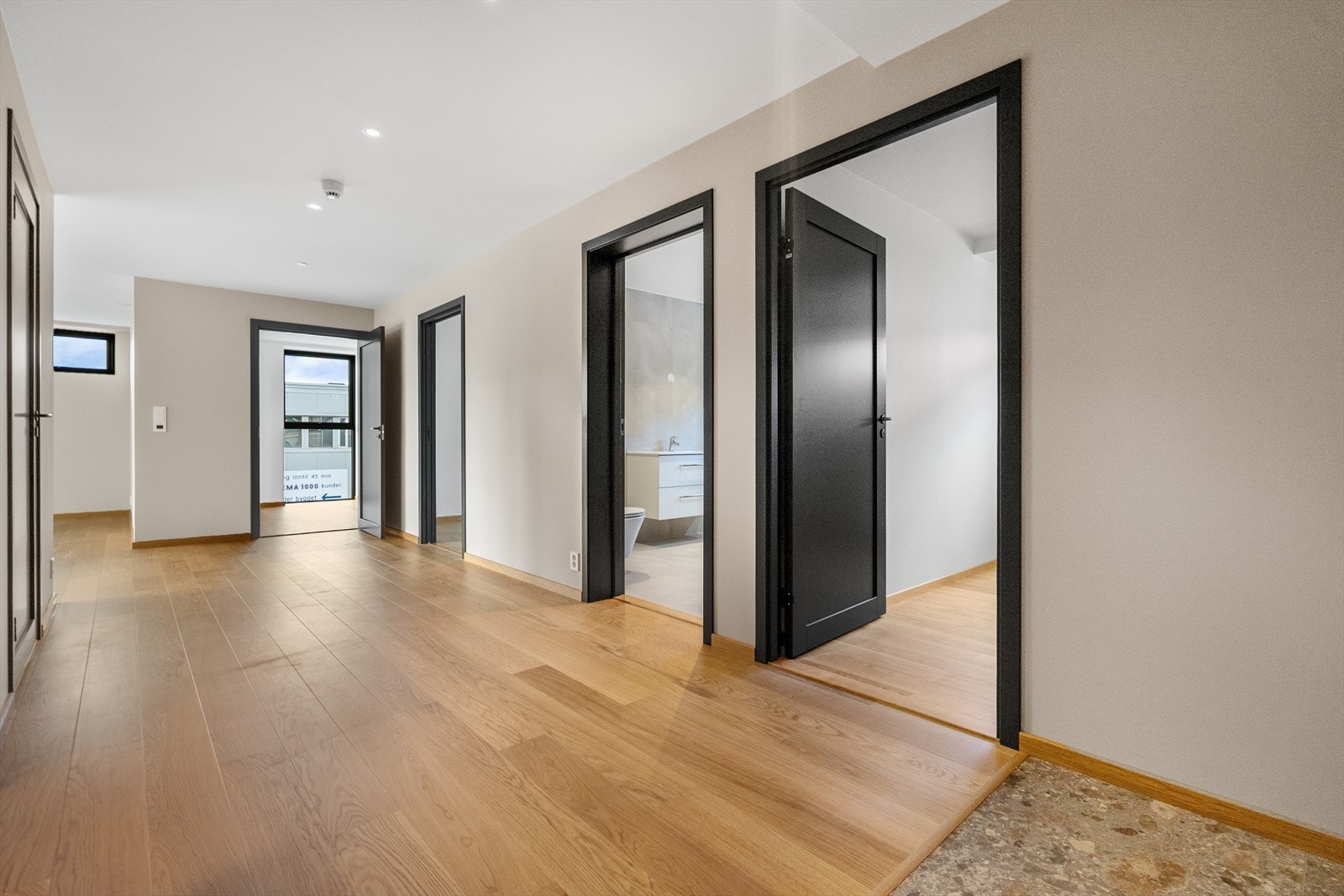 Lys og åpen gang som binder sammen leilighetens tre soverom, bad og vaskerom - praktisk og luftig planløsning Galleribilde