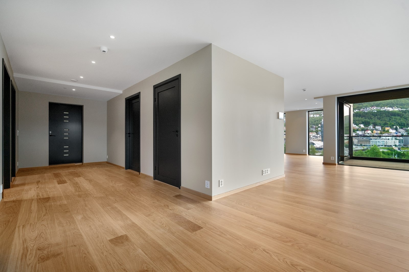 Romslig gang med nydelig eikegulv og god plass til oppbevaringsløsninger - herfra har du direkte adkomst til stue og veranda Galleribilde