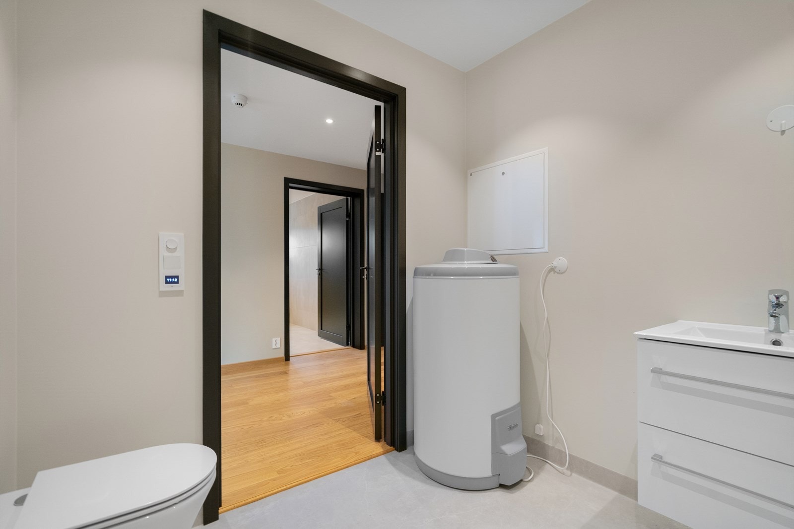 Praktisk vaskerom med varmtvannsbereder, servant og god plass til vaskemaskin og tørketrommel Galleribilde