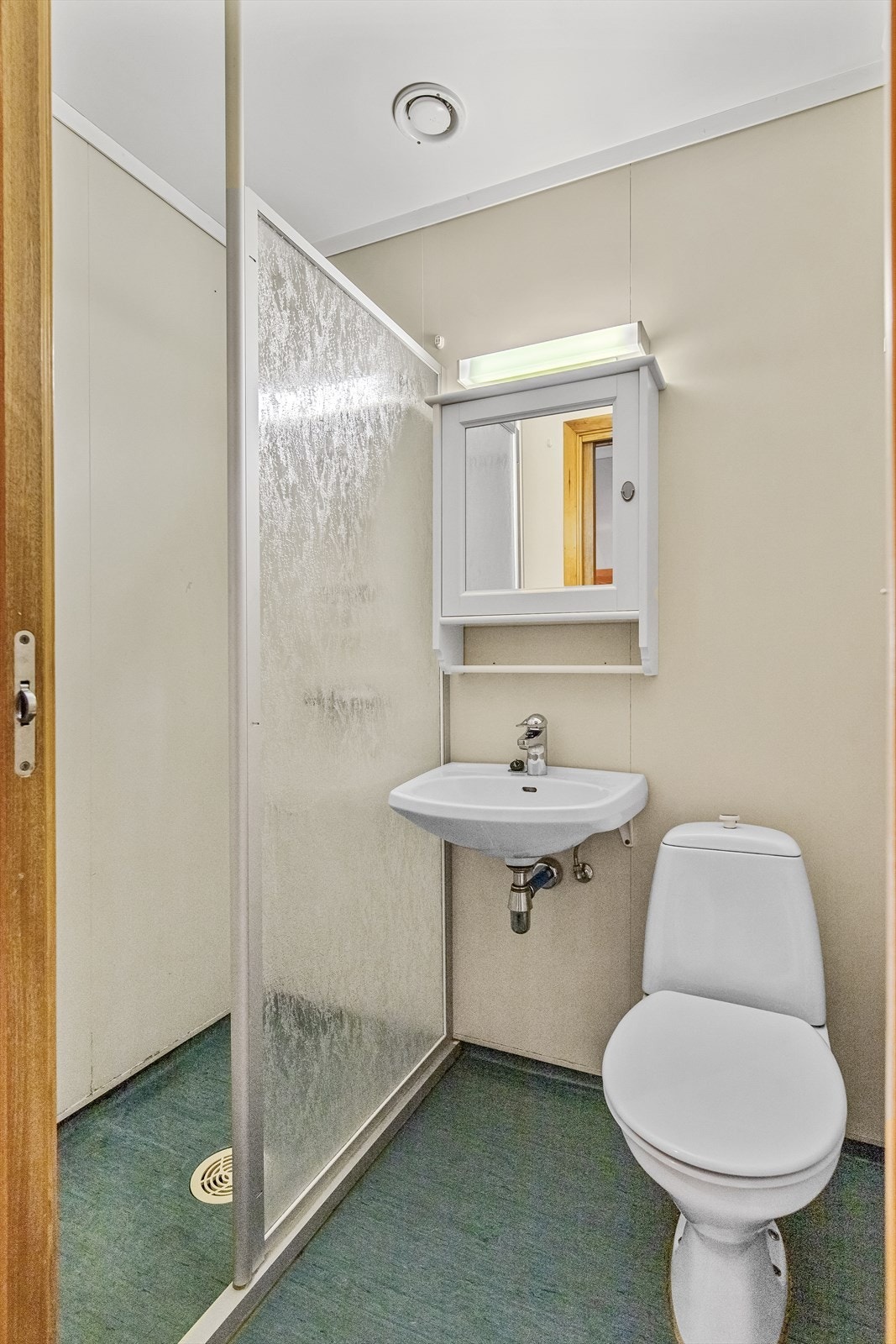 Badet er innredet med dusjnisje, servant og toalett med skyvedør. Badet har behov for modernisering Galleribilde