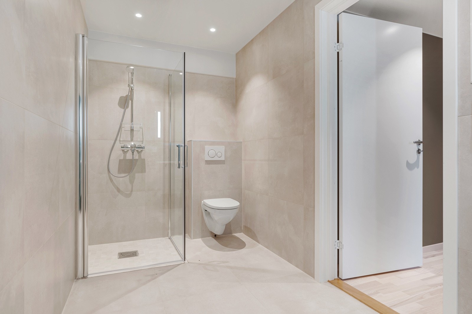 Innbydende bad med flislagte overflater, downlights i himling og behagelig gulvvarme. Galleribilde