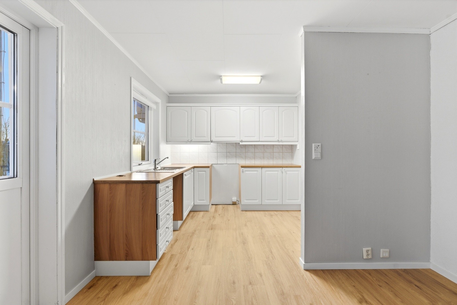 Kjøkkeninnredningen har profilerte fronter og benkeplate med nedfelt servant. Galleribilde