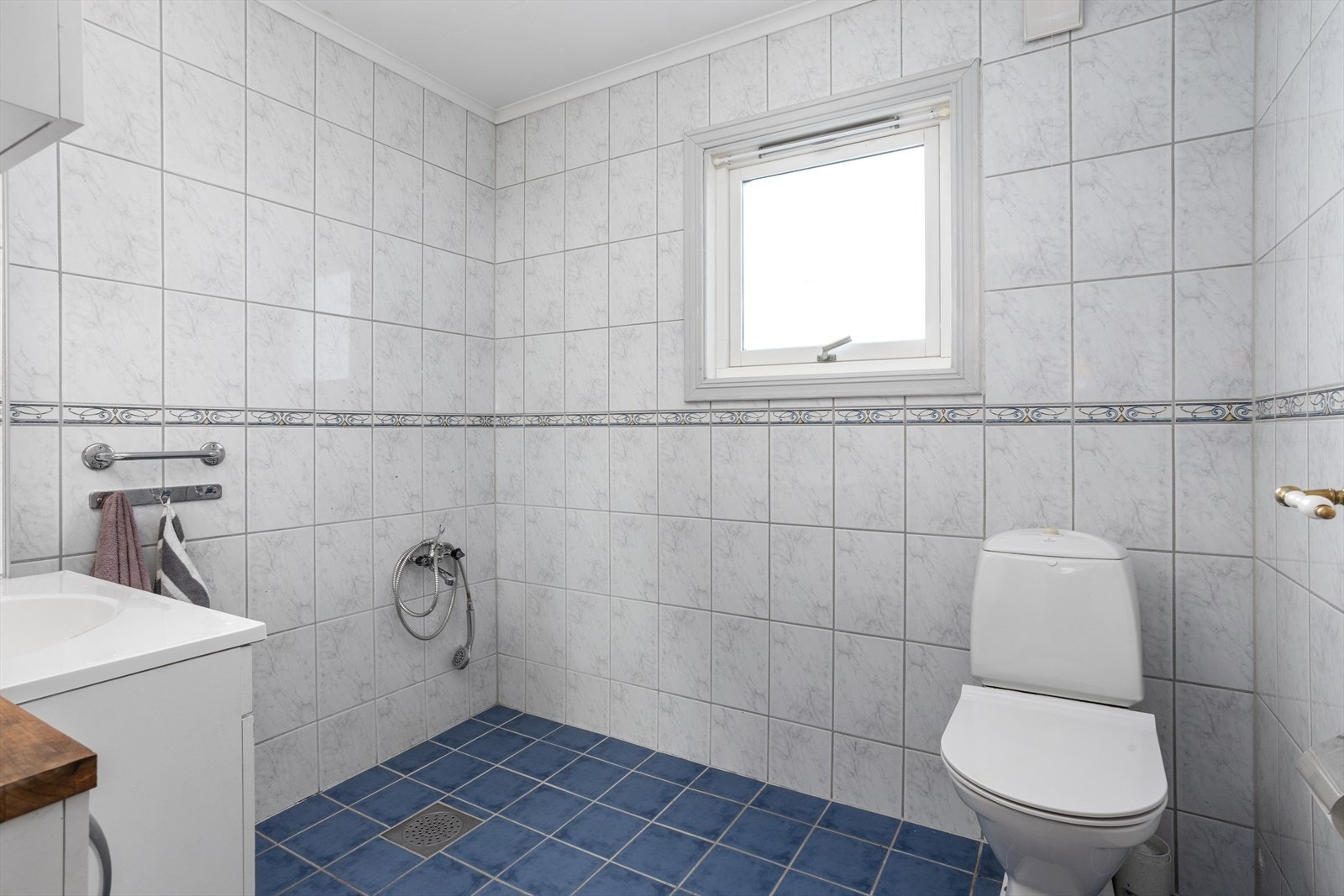 Badet er innredet med toalett og dusj og innredning med nedfelt servant. Galleribilde