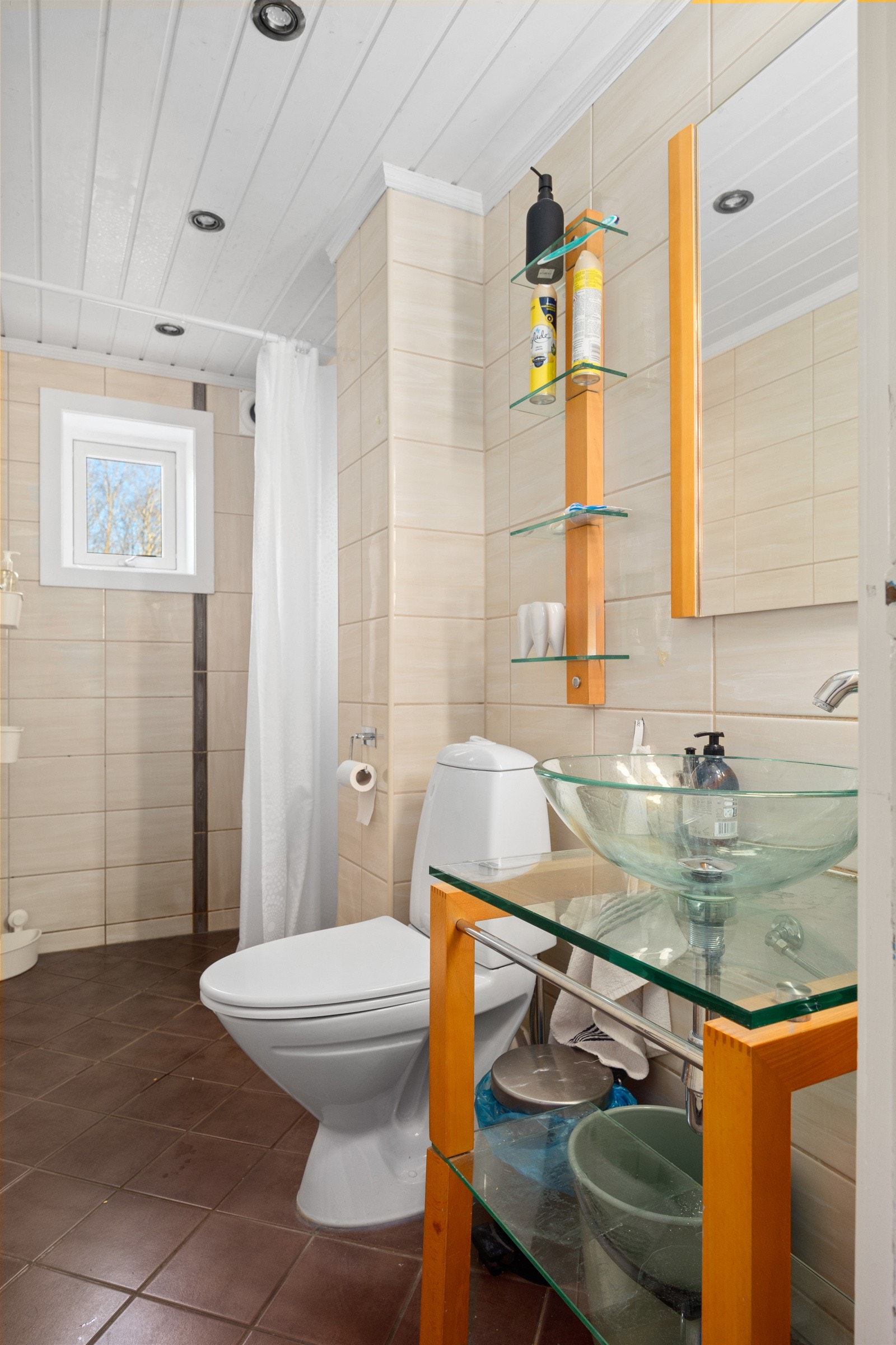 Flislagt badero med varmekabler i gulv, bolleservant, speil, lys og toalett. Galleribilde