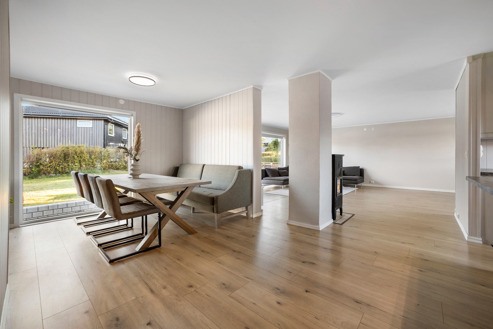 Romslig spisestue med praktisk plassering ved kjøkkenet og inndelt fra resten av stua Galleribilde