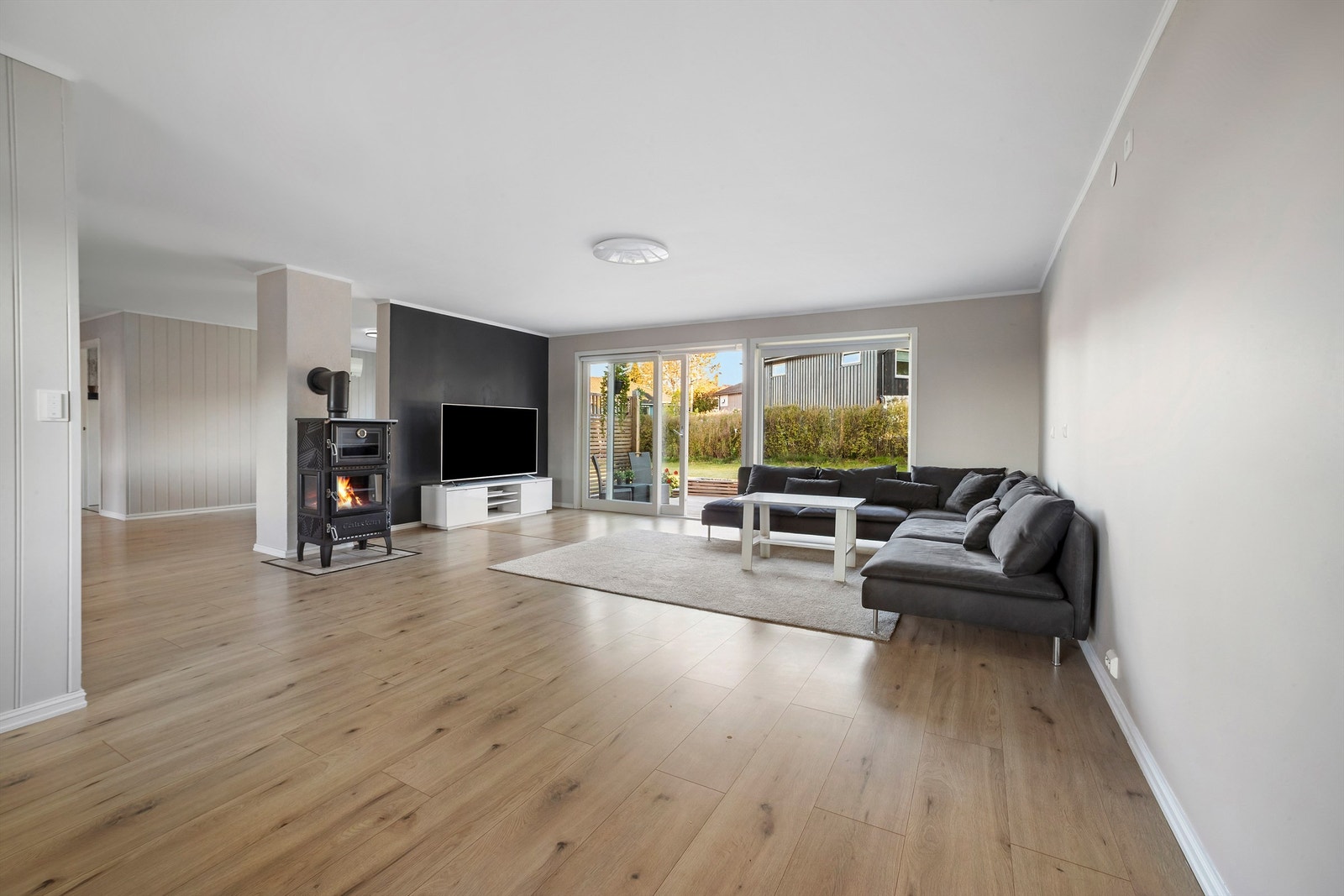 Stuen har lyse, malte vegger kombinert med panel, og gulvet er lagt med laminat Galleribilde