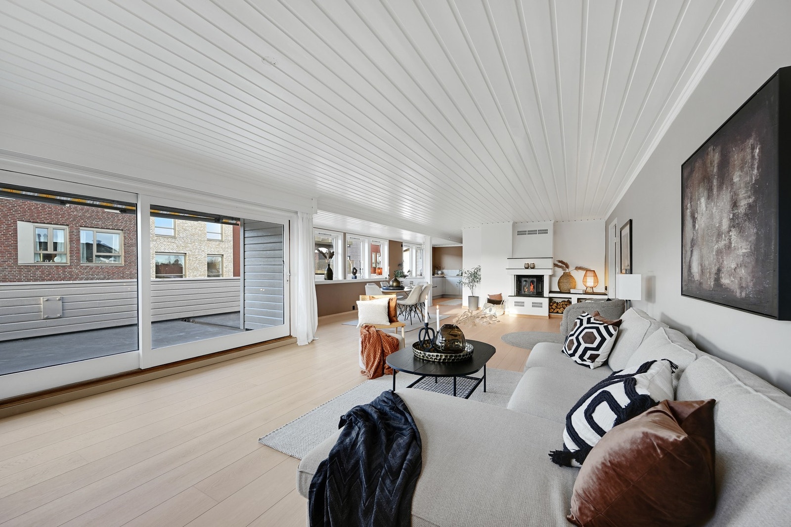 Her ser vi et oversiktsbilde av allrommet - peis og hev-skyvedører ut til terrassen Galleribilde