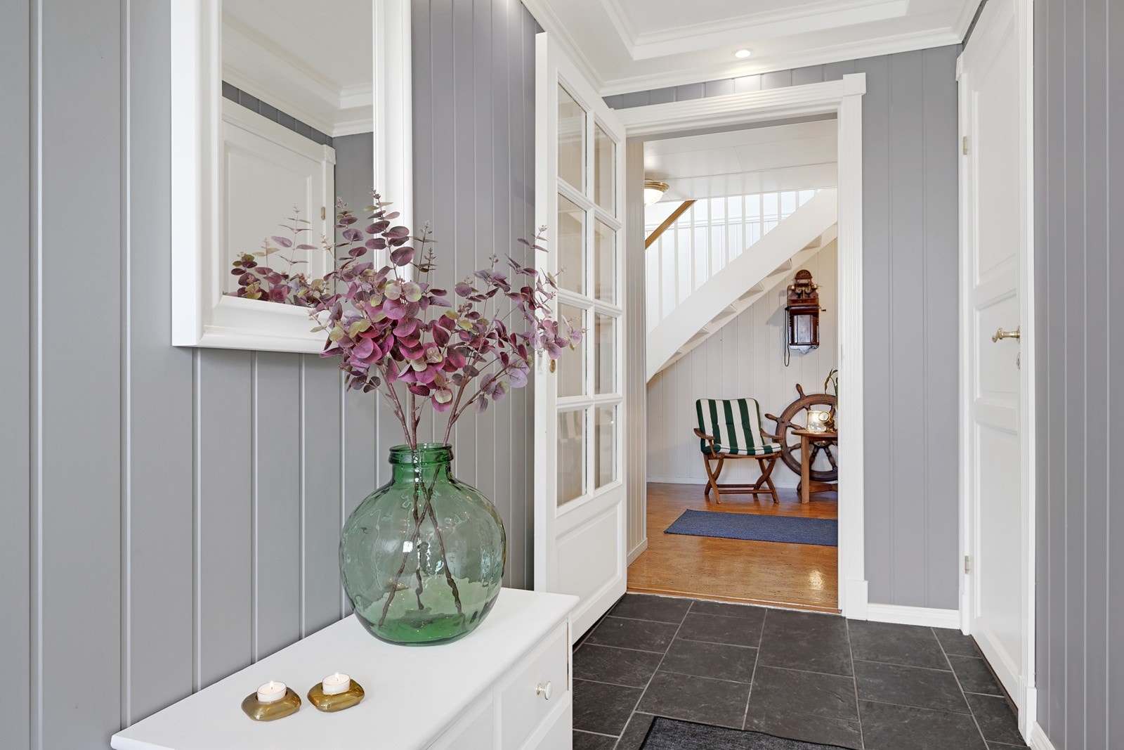 Flislagt gulv og malte vegger i tidsriktige farger. Her har man plass til klesoppheng og sko Galleribilde