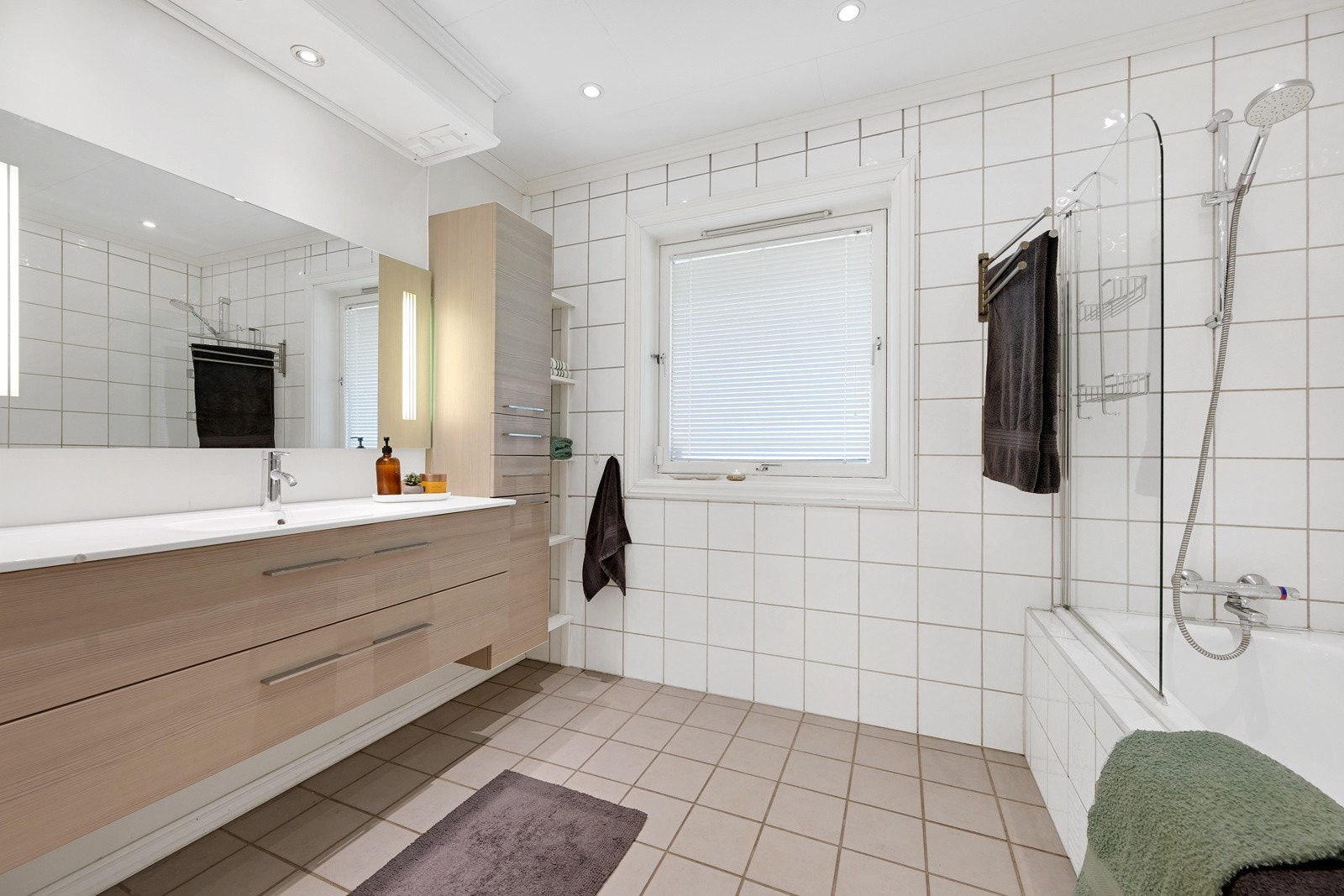 Pent baderom fra byggeår med innredning av god størrelse. Her har man badekar og klosett og downlights gir rommet en behagelig atmosfære Galleribilde