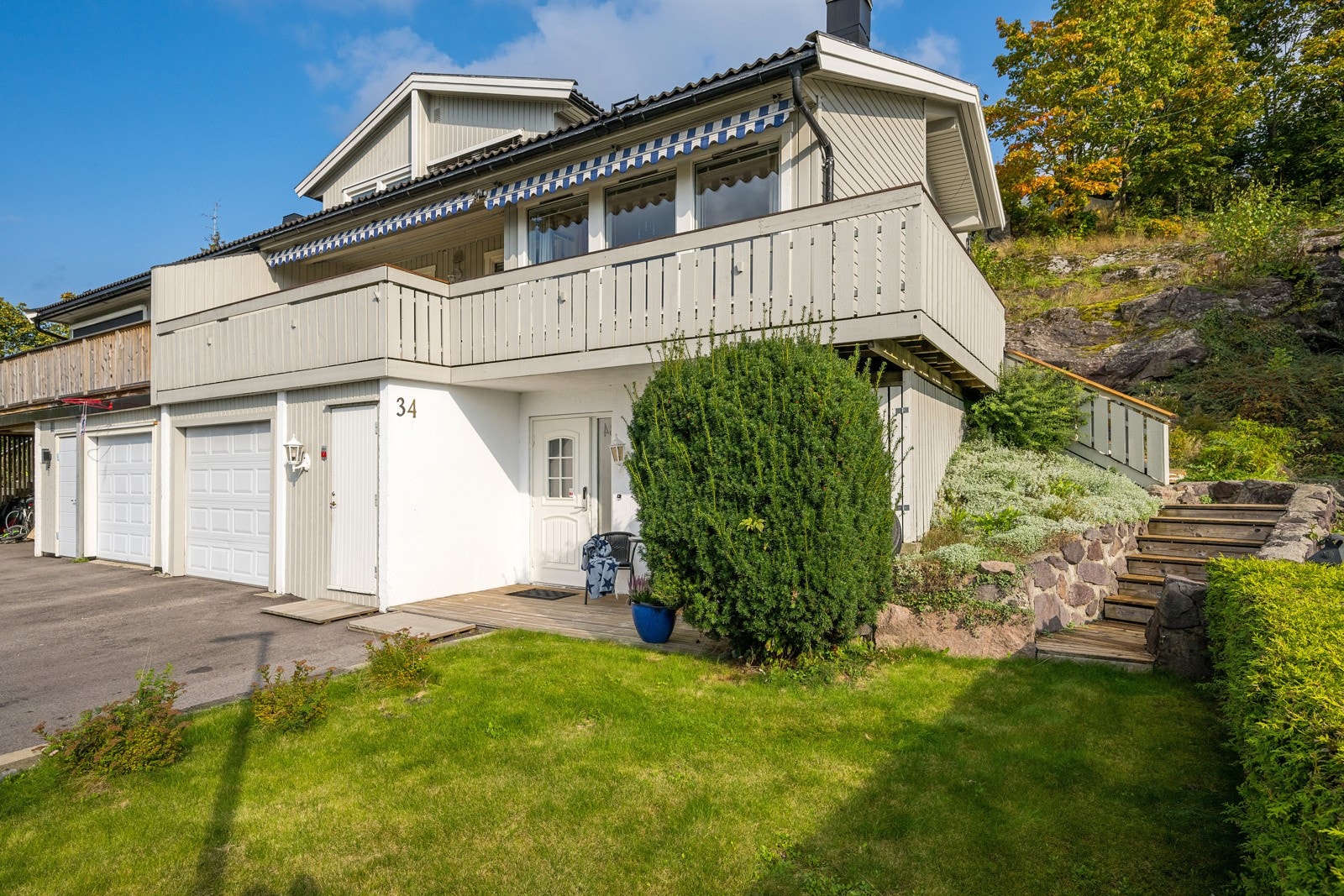 Pent opparbeidet hage med beplantning og trapp til balkong, naturlig lagt i samspill med naturen Galleribilde