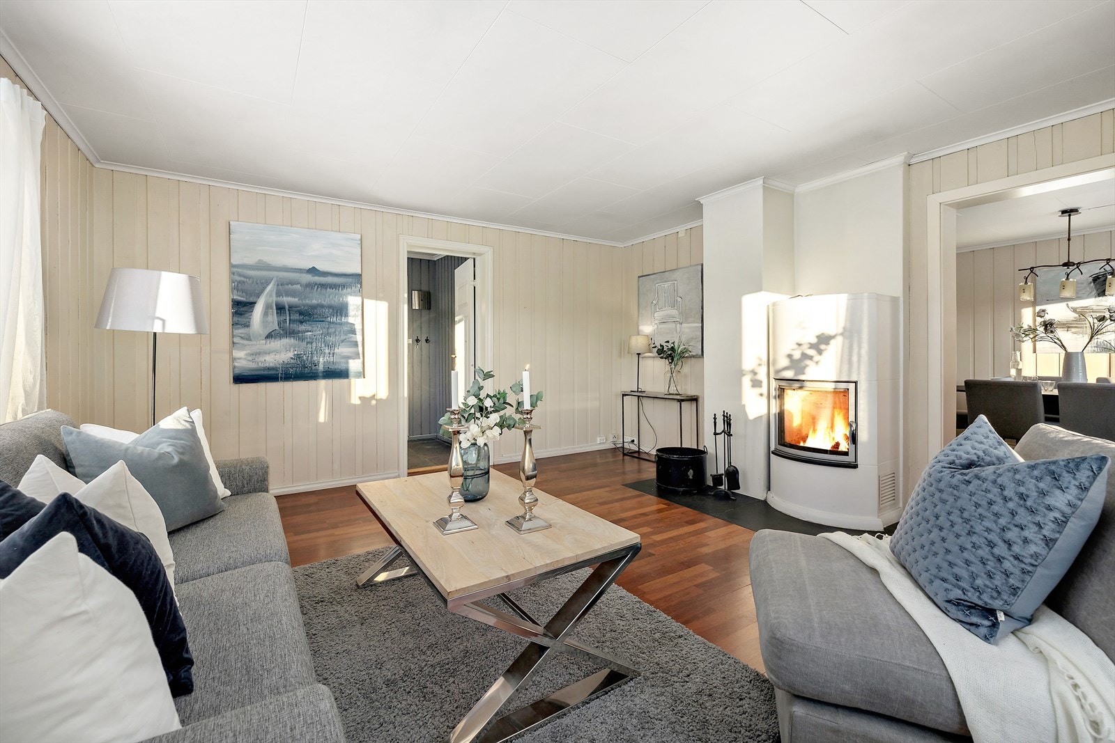 Romslig stue med vedovn. Det gamle bygget har blitt avstivet med bjelker i gulvet og lagt vannbåren varme. Galleribilde