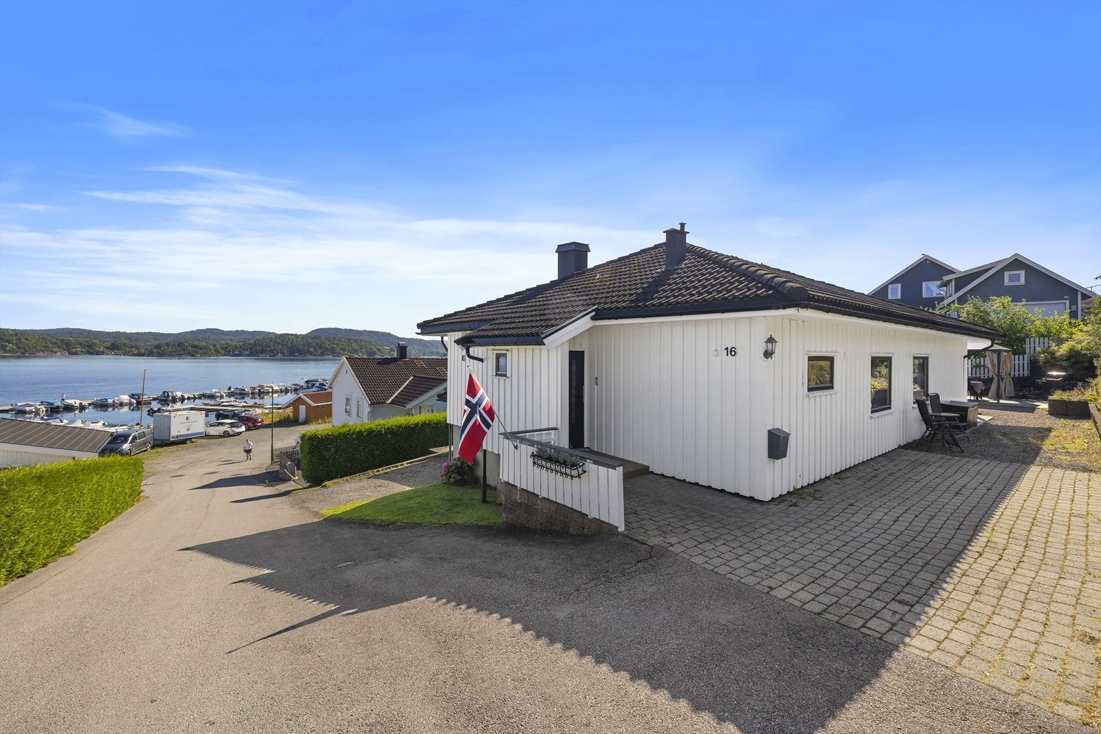 Inngangspartiet har belegningsstein og det er plass til å parkere en bil Galleribilde