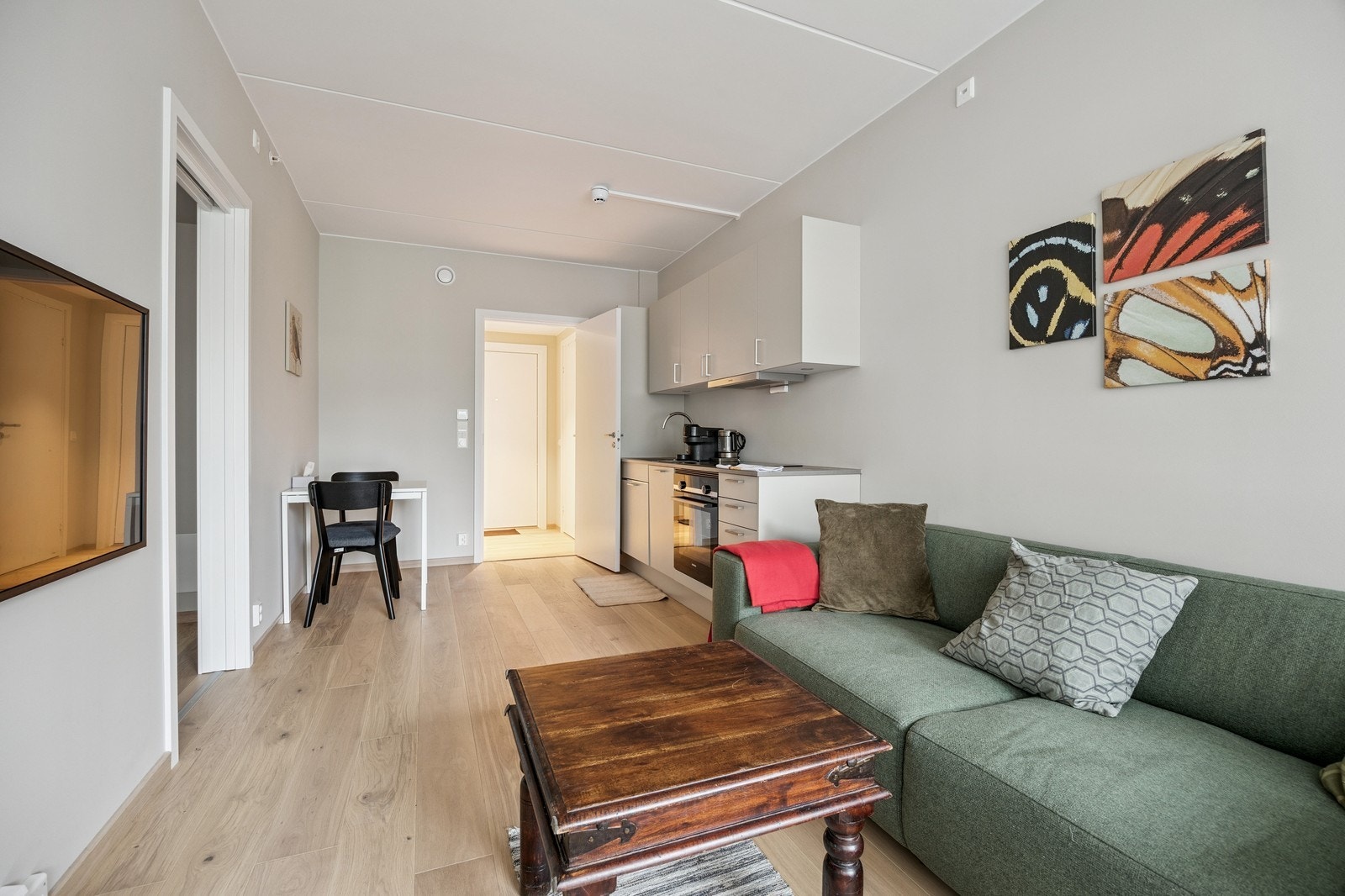 Koslig stue med sofa, salongbord og vegghengt tv. Galleribilde