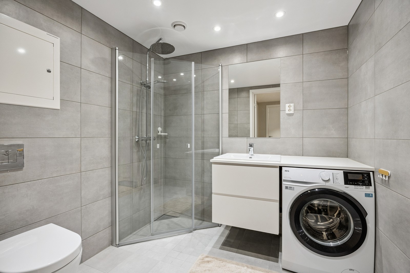 Bad med vaskemaskin, dusj, servant og toalett. Galleribilde