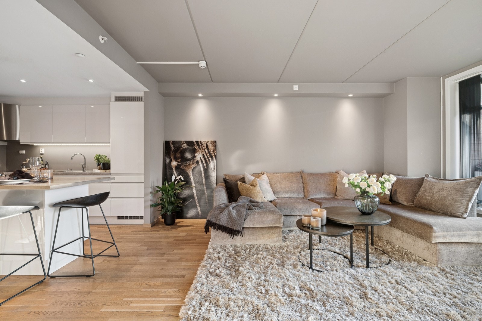 Lys og romslig stue med moderne innredning og plass til en stor sofagruppe. Åpen løsning mot kjøkken gir en sosial og funksjonell planløsning. Galleribilde