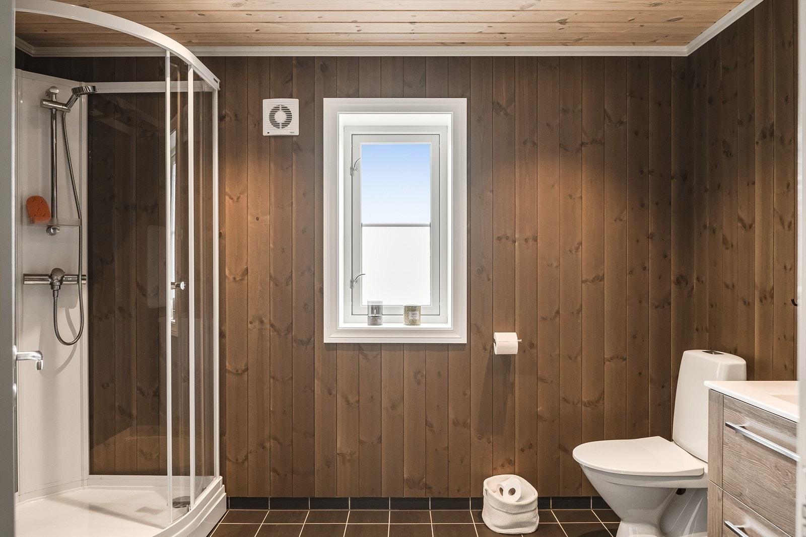 Hytta har et innbydende baderom fra byggeåret 2020. Baderommet har mørke fliser på gulv med gulvvarme, lun panel på veggene, downlights i himlingen og mekanisk avtrekk. Galleribilde