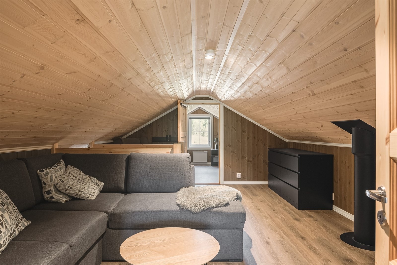 Koselig loftstue med plass til både sofa og lesekrok. Det gjøres oppmerksom på at hemsen ikke har målbare arealer og er ikke godkjent for varig opphold. Galleribilde