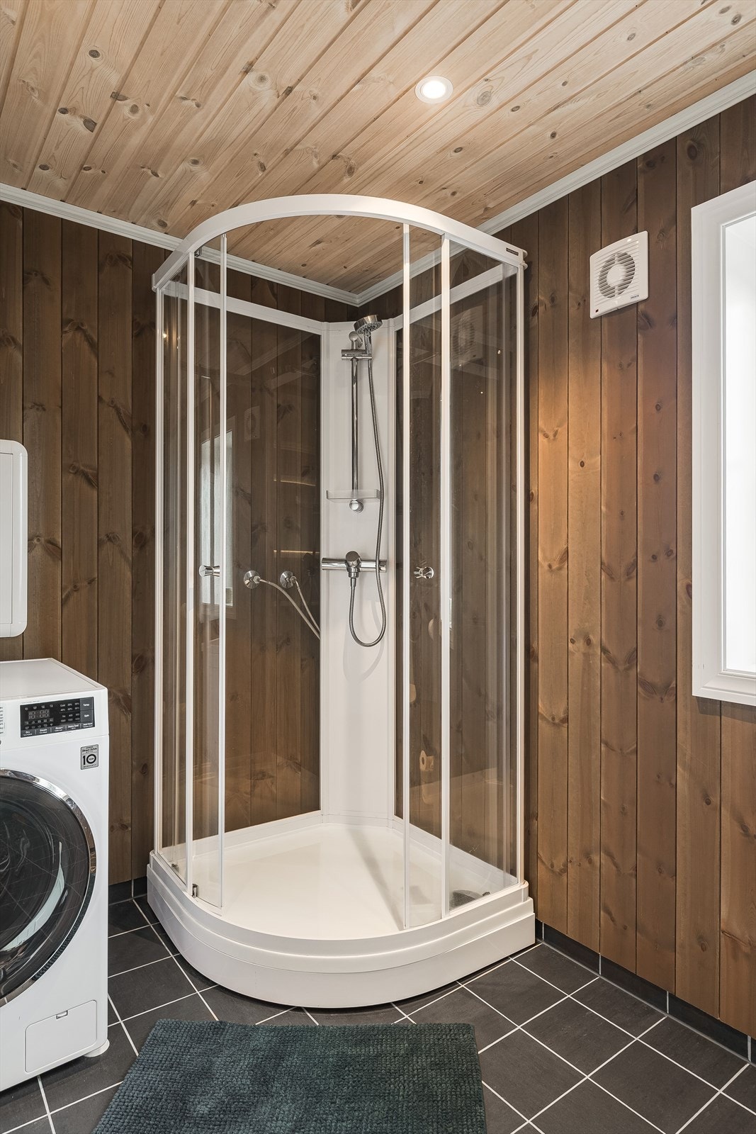 Baderommet er også utstyrt med dusjkabinett, gulvstående toalett og opplegg for vaskemaskin. Galleribilde