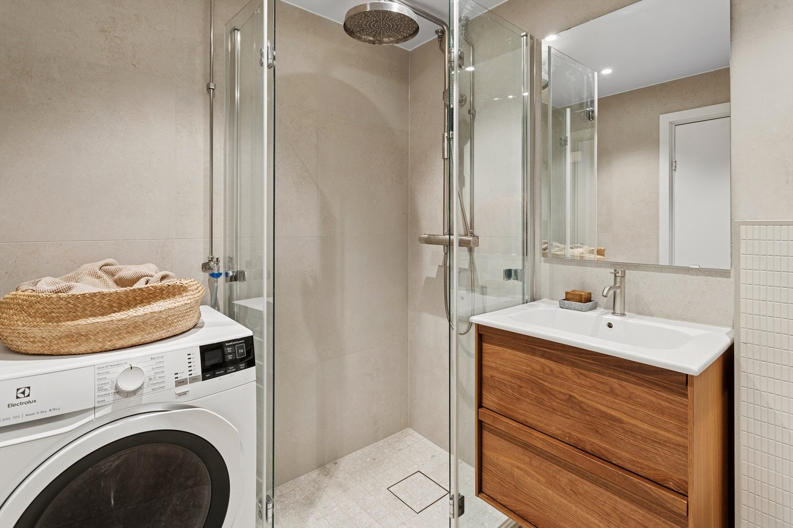 Baderommet har innredning med servantskap og heldekkende servant, speil, vegghengt toalett og dusjhjørne med leddede dører. Det er også opplegg for vaskemaskin. Galleribilde