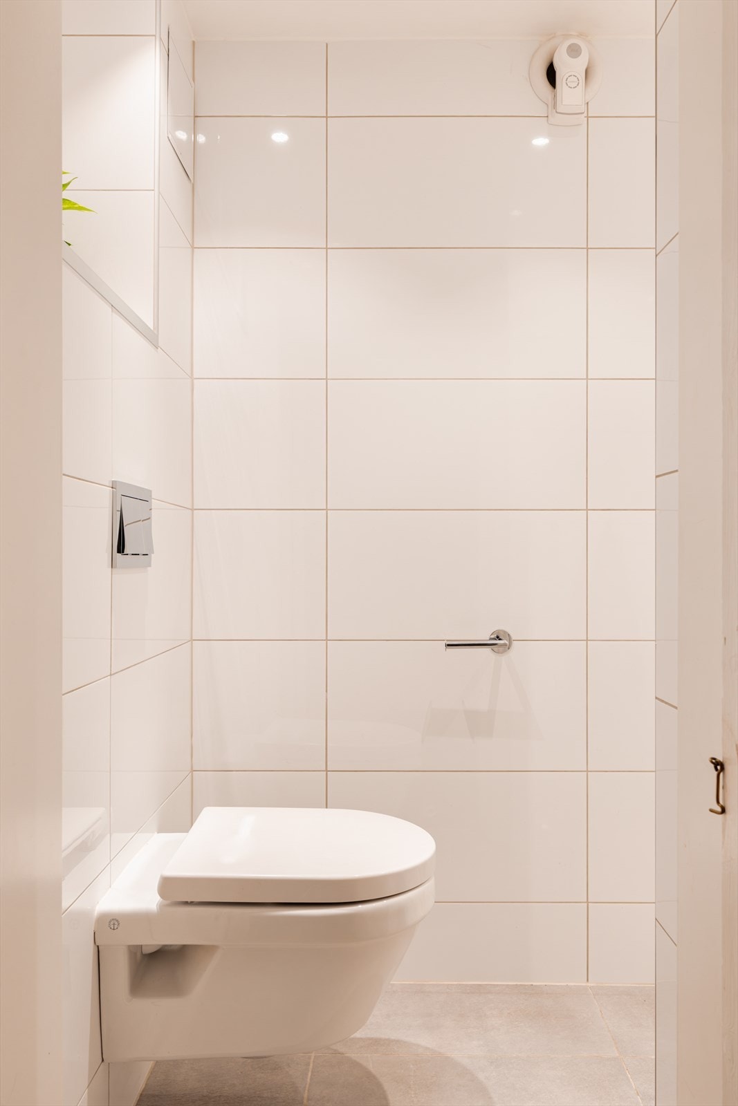 Badet er utstyrt med servantskap med skuffeseksjon, speilskap, vegghengt toalett og dusjhjørne med rullestein. Galleribilde